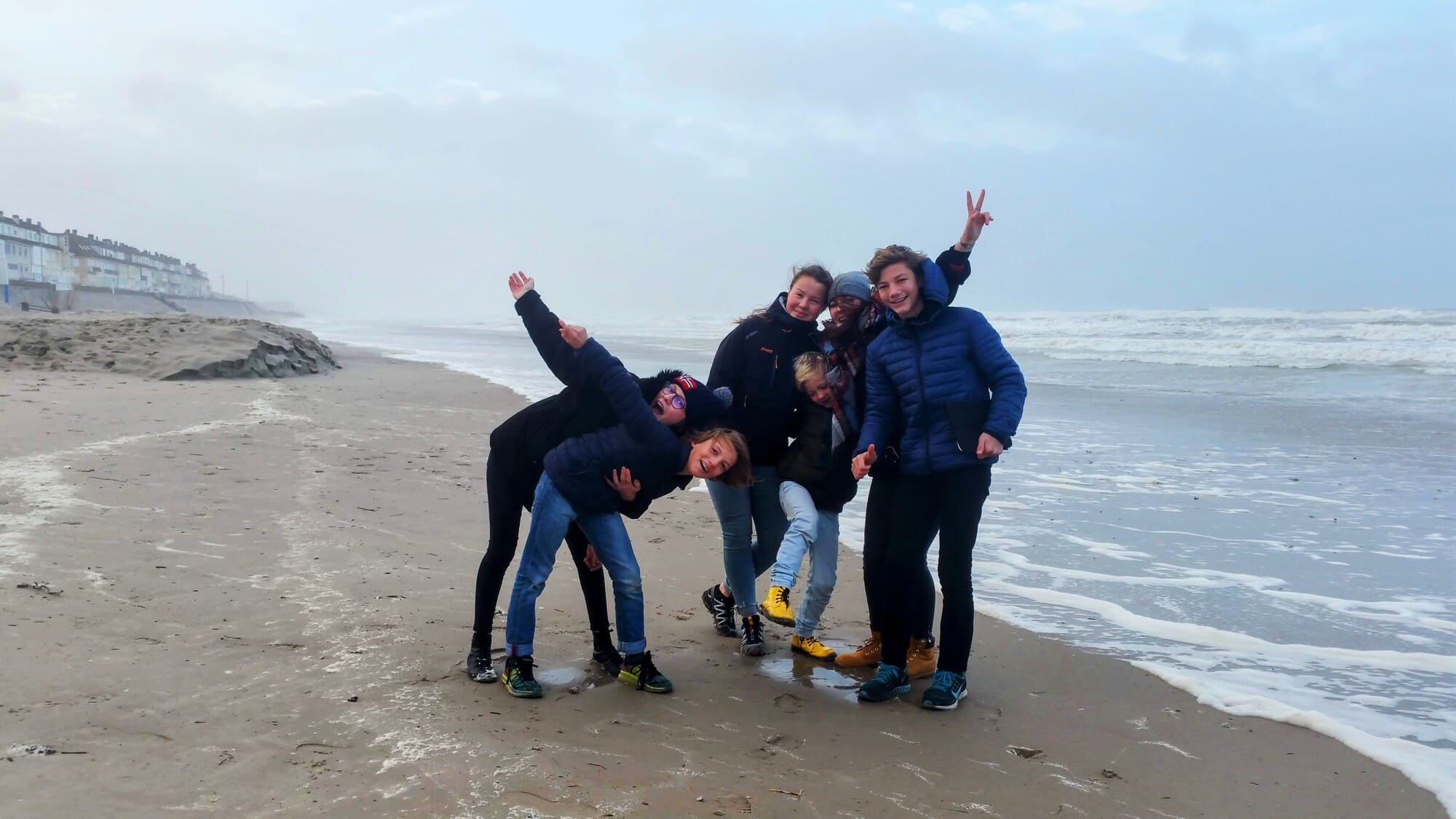 Jeunes Françaises et Norvégiennes riant ensemble sur une plage en Norvège — symbole d’amitié, de partage et de découvertes culturelles lors d’un échange familial